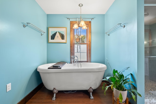 3694 Kerlikowske Rd, Coloma, MI 49038 - bathroom featuring a chandelier, a soaking tub, baseboards, and wood finished floors