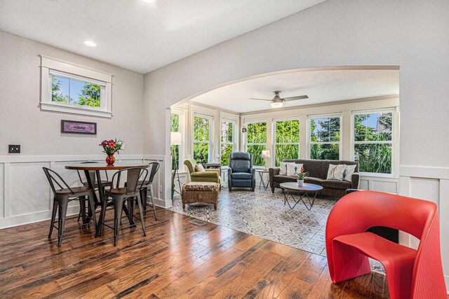 7251 E Beach Dr, South Haven, MI 49090 - dining space featuring arched walkways, plenty of natural light, a decorative wall, hardwood / wood-style flooring, and a wainscoted wall