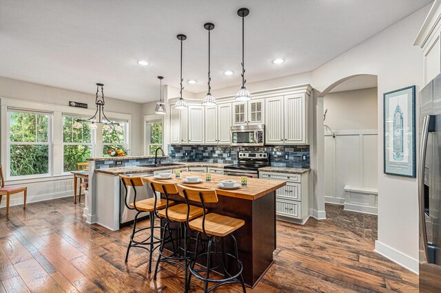 7251 E Beach Dr, South Haven, MI 49090 - kitchen featuring stainless steel appliances, butcher block countertops, a peninsula, a sink, and a kitchen breakfast bar