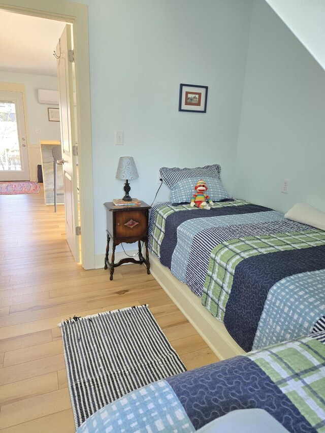 7251 E Beach Dr, South Haven, MI 49090 - bedroom featuring a wall mounted air conditioner and wood finished floors