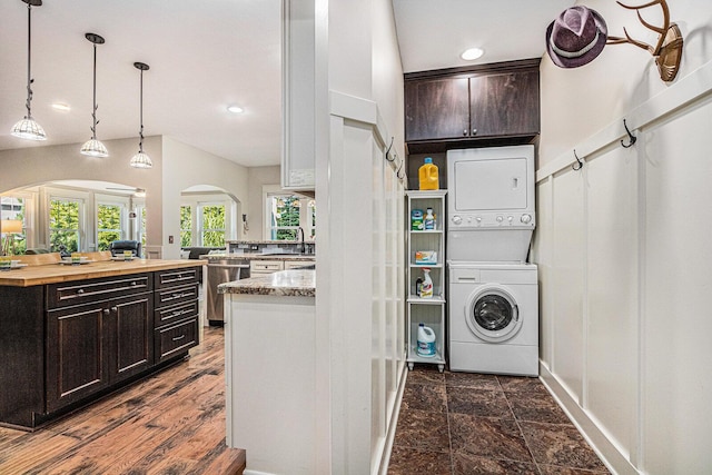 7251 E Beach Dr, South Haven, MI 49090 - washroom featuring arched walkways, estacked washer and dryer, baseboards, and recessed lighting