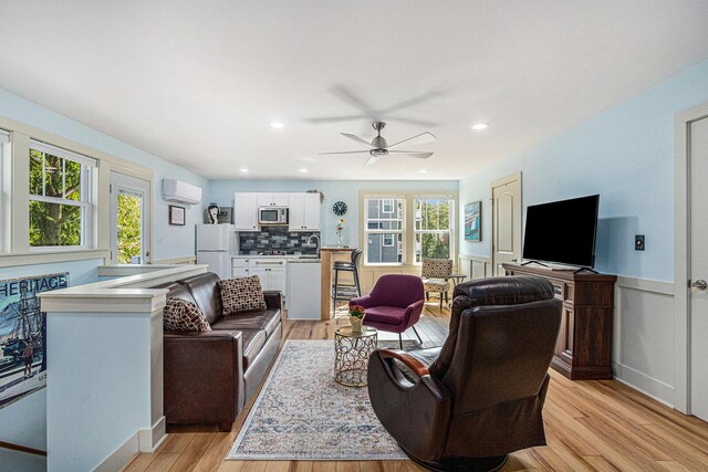 7251 E Beach Dr, South Haven, MI 49090 - living area featuring an AC wall unit, light wood finished floors, a ceiling fan, a wainscoted wall, and recessed lighting