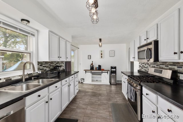 8131 Lorac St, Portage, MI 49002 - kitchen with stainless steel appliances, a sink, dark countertops, and plenty of natural light