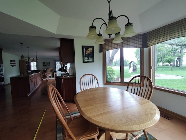 dining area with dark wood-style flooring, a chandelier, and baseboards