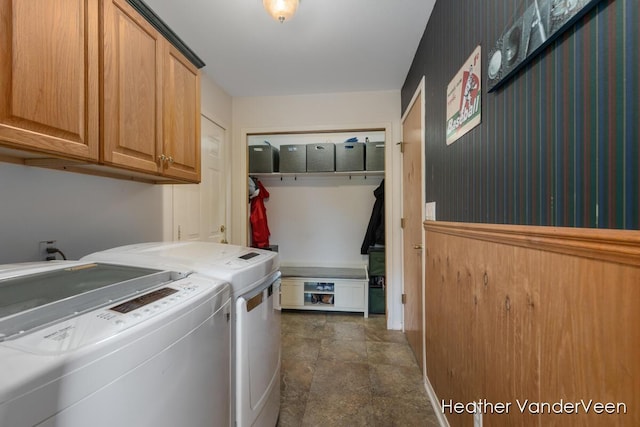 laundry room with cabinet space, separate washer and dryer, and stone finish floors