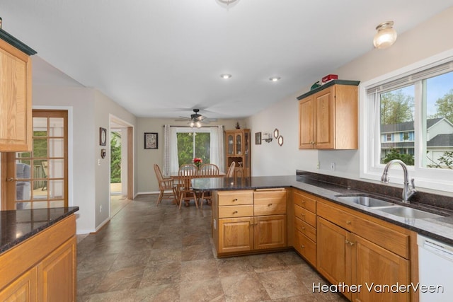 kitchen with a sink, white dishwasher, plenty of natural light, a peninsula, and recessed lighting