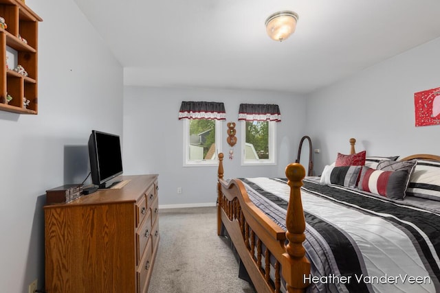 bedroom with light colored carpet and baseboards