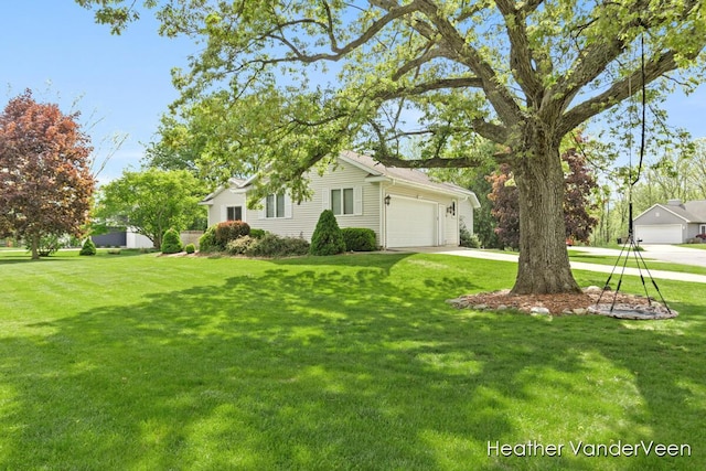 view of side of property featuring a garage, driveway, and a lawn