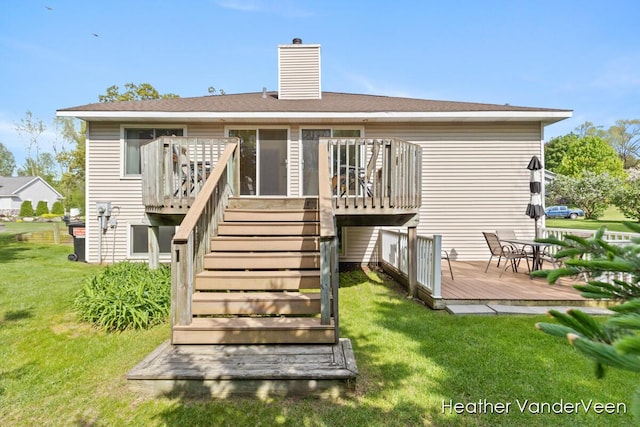 back of property with a deck, a chimney, a lawn, and stairs