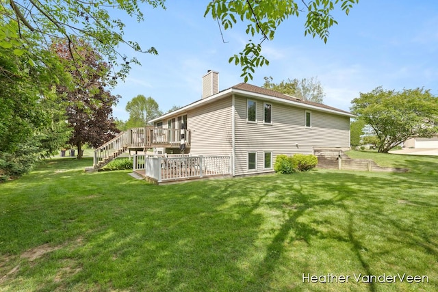 back of house with a wooden deck, a chimney, a yard, and stairs