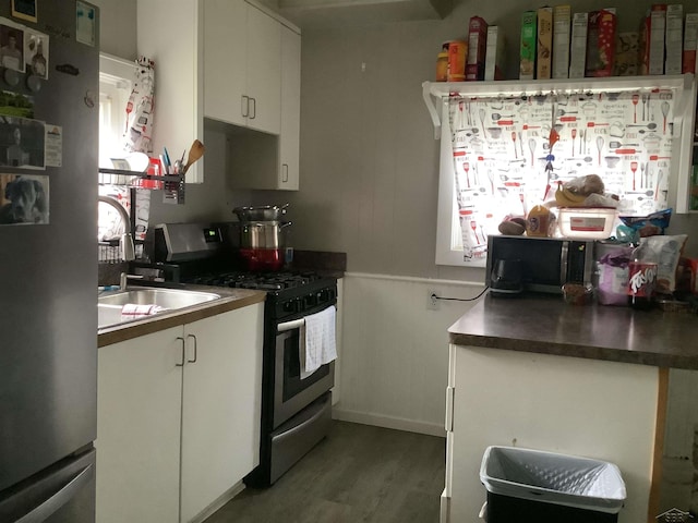 508 N Roosevelt Austin Ave, Saginaw, MI 48607 - kitchen with appliances with stainless steel finishes, white cabinets, wood finished floors, and dark countertops
