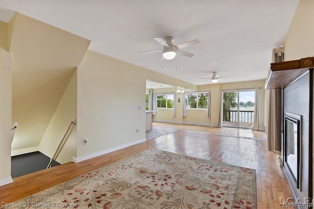 117 Studer Dr, Grass Lake, MI 49240 - unfurnished living room with wood-type flooring, a ceiling fan, a glass covered fireplace, and baseboards