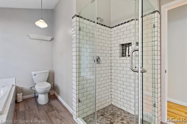 117 Studer Dr, Grass Lake, MI 49240 - bathroom with a shower stall, a bath, wood finished floors, and toilet