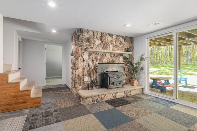 living area with a wood stove, recessed lighting, stairway, and baseboards