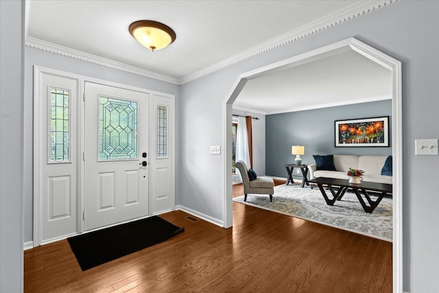 6588 White Pines Dr, Brighton, MI 48116 - foyer featuring arched walkways, ornamental molding, dark wood finished floors, and baseboards