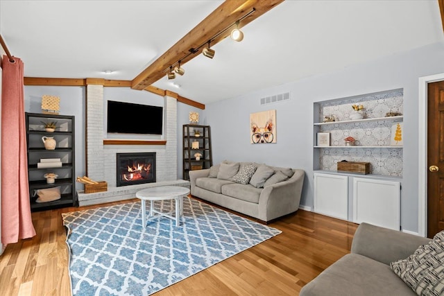 6588 White Pines Dr, Brighton, MI 48116 - living area with rail lighting, wood finished floors, and a fireplace