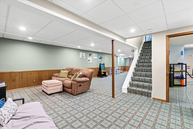 6588 White Pines Dr, Brighton, MI 48116 - carpeted living room featuring a drop ceiling, stairway, a wainscoted wall, recessed lighting, and wood walls