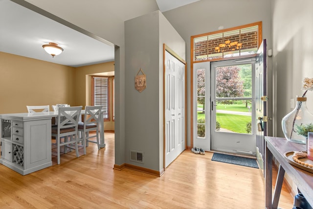 foyer entrance with light wood-style flooring and baseboards