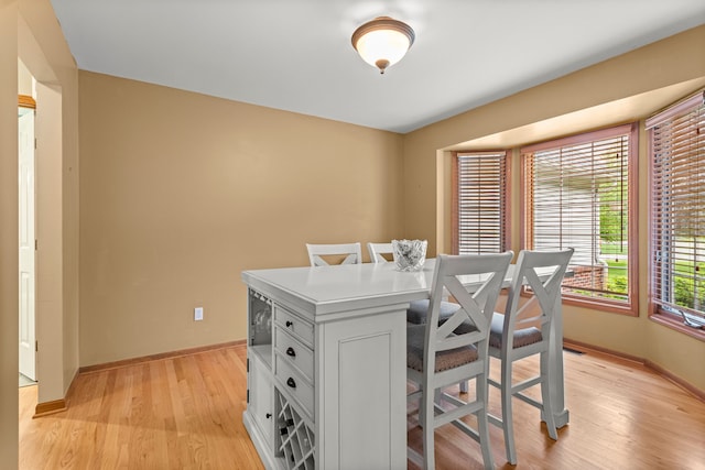 dining space featuring light wood-style floors and baseboards