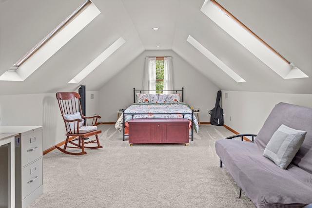 bedroom with a skylight, light colored carpet, vaulted ceiling, and baseboards