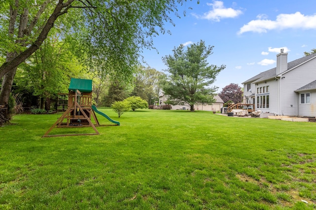 view of green lawn featuring a playground