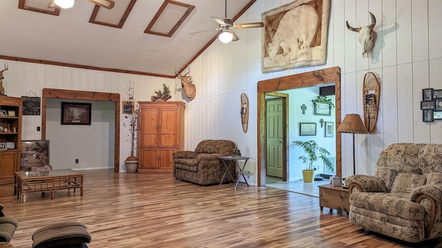 7884 N Saint Helen Rd, Saint Helen, MI 48656 - living room with wood walls, a ceiling fan, wood finished floors, high vaulted ceiling, and crown molding