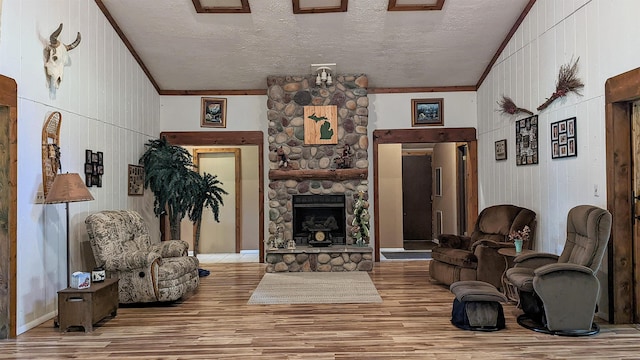 7884 N Saint Helen Rd, Saint Helen, MI 48656 - living area featuring wood finished floors, crown molding, a stone fireplace, a textured ceiling, and wood walls