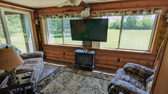 7884 N Saint Helen Rd, Saint Helen, MI 48656 - living area with a wood stove, plenty of natural light, and ceiling fan