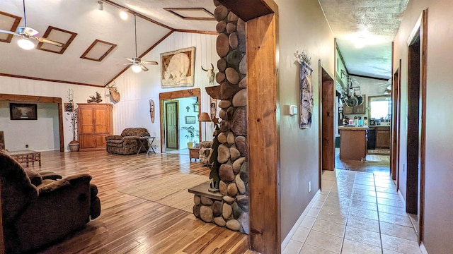 7884 N Saint Helen Rd, Saint Helen, MI 48656 - living room featuring vaulted ceiling, ceiling fan, crown molding, wood finished floors, and baseboards