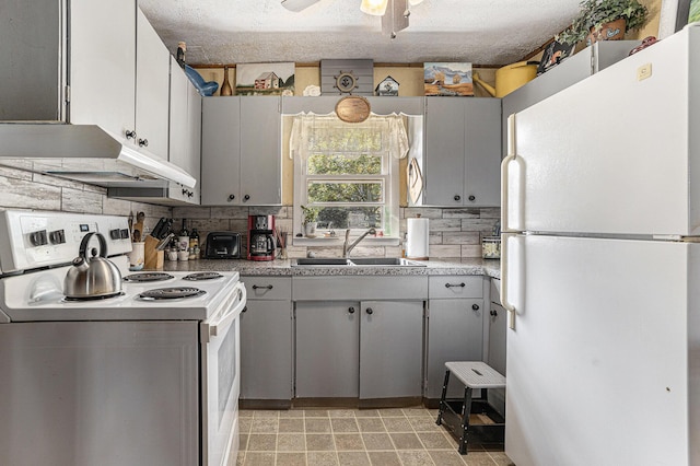 6520 Oakwood Dr, Delton, MI 49046 - kitchen featuring white appliances, a sink, under cabinet range hood, backsplash, and gray cabinetry