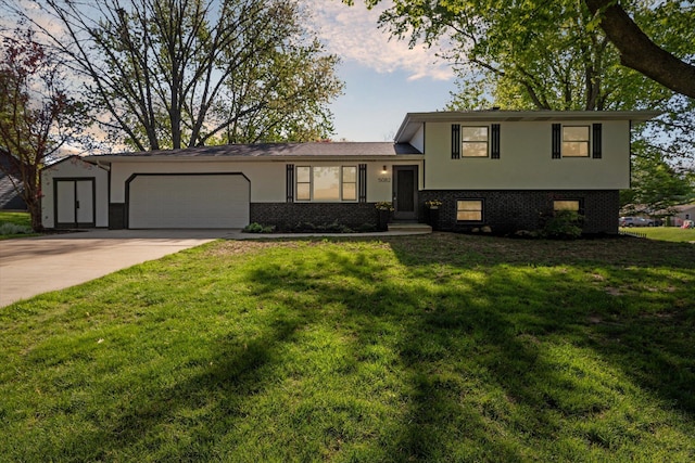 5082 Patland Dr, Kalamazoo, MI 49009 - tri-level home with a garage, concrete driveway, stucco siding, a front yard, and brick siding