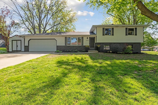 5082 Patland Dr, Kalamazoo, MI 49009 - tri-level home featuring an attached garage, brick siding, stucco siding, a front yard, and concrete driveway
