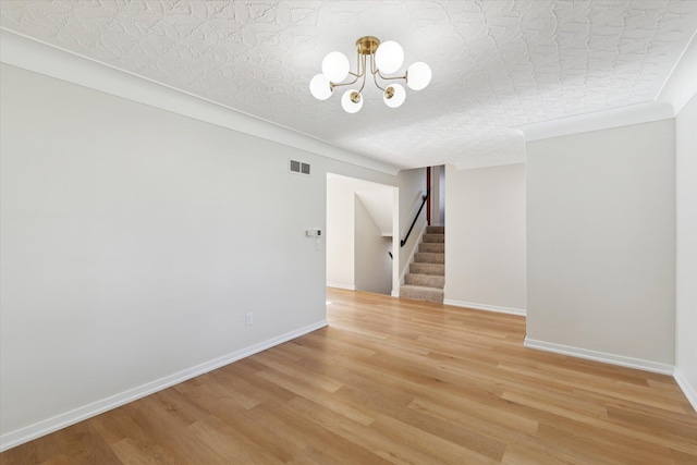 5082 Patland Dr, Kalamazoo, MI 49009 - unfurnished room featuring stairs, light wood-style flooring, a chandelier, and baseboards
