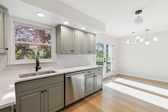 5082 Patland Dr, Kalamazoo, MI 49009 - kitchen with dishwasher, gray cabinets, a sink, backsplash, and light countertops