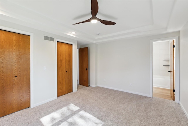 5082 Patland Dr, Kalamazoo, MI 49009 - unfurnished bedroom featuring a raised ceiling, carpet floors, baseboards, ensuite bathroom, and ceiling fan