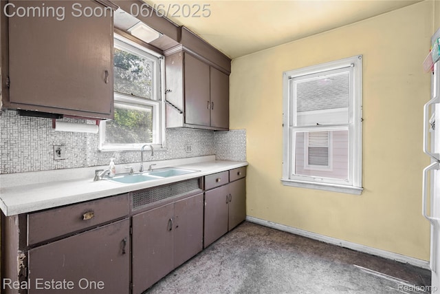 2209 Ridgemont Rd, Grosse Pointe Woods, MI 48236 - kitchen with a sink, backsplash, light countertops, and baseboards