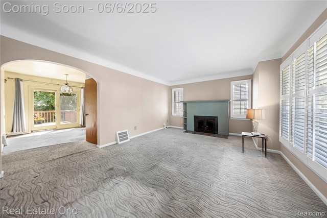 2209 Ridgemont Rd, Grosse Pointe Woods, MI 48236 - unfurnished living room with arched walkways, a brick fireplace, baseboards, and carpet flooring