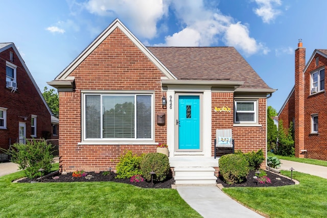 bungalow-style house featuring brick siding, a front lawn, and a shingled roof