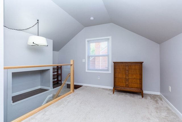 additional living space with carpet floors, lofted ceiling, and baseboards