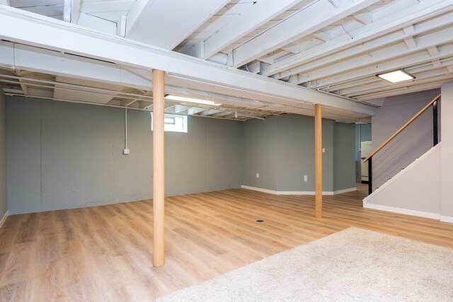 below grade area featuring wood finished floors and stairway