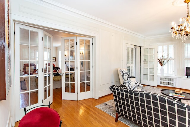 736 Chicago Blvd, Detroit, MI 48202 - sitting room featuring french doors, crown molding, wood finished floors, a chandelier, and radiator heating unit