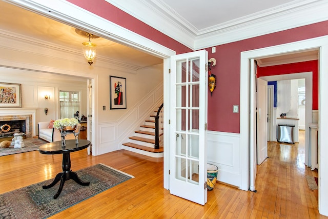 736 Chicago Blvd, Detroit, MI 48202 - entrance foyer featuring crown molding, stairway, light wood-type flooring, a wainscoted wall, and a fireplace