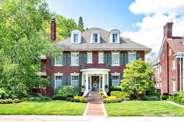 736 Chicago Blvd, Detroit, MI 48202 - colonial home with brick siding, a front lawn, and a chimney