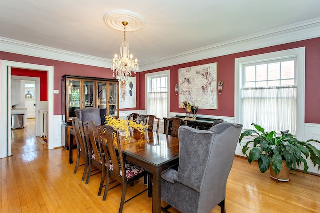 736 Chicago Blvd, Detroit, MI 48202 - dining space with a chandelier, wainscoting, ornamental molding, light wood-style flooring, and a decorative wall