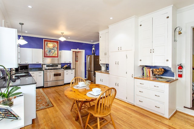 736 Chicago Blvd, Detroit, MI 48202 - kitchen featuring stainless steel appliances, dark countertops, decorative backsplash, crown molding, and light wood-style flooring