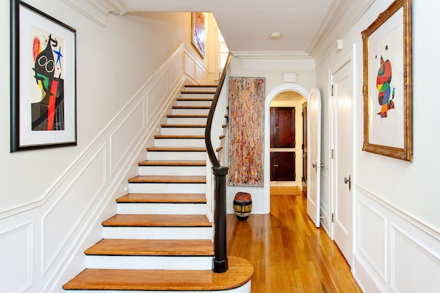 736 Chicago Blvd, Detroit, MI 48202 - stairway featuring arched walkways, crown molding, a decorative wall, wood finished floors, and wainscoting