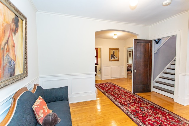 736 Chicago Blvd, Detroit, MI 48202 - corridor featuring arched walkways, light wood-style flooring, stairs, a wainscoted wall, and ornamental molding