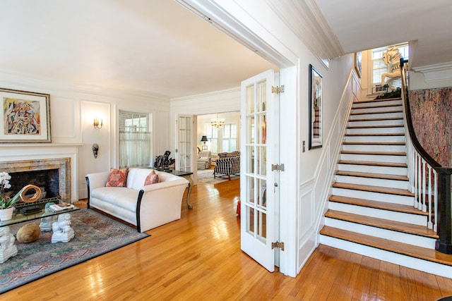 736 Chicago Blvd, Detroit, MI 48202 - living room featuring ornamental molding, stairs, a chandelier, light wood-style floors, and a fireplace