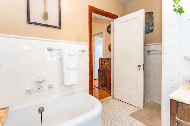 736 Chicago Blvd, Detroit, MI 48202 - bathroom featuring tile walls, a bathtub, a wainscoted wall, and tile patterned flooring