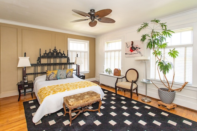 736 Chicago Blvd, Detroit, MI 48202 - bedroom featuring wood finished floors, crown molding, baseboards, a decorative wall, and radiator